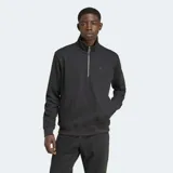 Buzo negro de cuello alto con cierre de media cremallera, de tejido texturizado tipo waffle. Tiene logo bordado en el pecho, bolsillos laterales y puños de canalé.