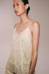 Top de tirantes finos confeccionado en hilatura con cupro, con diseño en tejido jacquard y aplicaciones de encaje a tono en el escote y el ruedo.