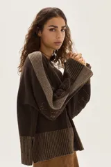Sweater de tejido de punto en color beige, con mangas largas que presentan detalles de textura en relieve y paneles laterales en tono gris. Confeccionado en lana italiana, cuenta con puños acanalados y detalles en lurex.
