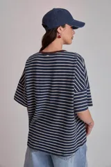 Remera oversize a rayas horizontales en tonos bordó y blanco, con cuello redondo verde oscuro y un pequeño parche bordado en forma de corazón en el pecho.