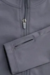 Campera deportiva gris de corte ajustado con cuello elevado, cierre frontal completo y mangas largas con abertura para el pulgar.