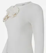 Suéter de punto color blanco, de corte ajustado y manga larga, con cuello redondo y detalle de aplicaciones de flores en relieve sobre el hombro derecho.
