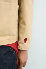 Sobrecamisa de corte relajado confeccionada en tejido de algodón con estructura canvas. Presenta cuello solapa, manga larga, cierre frontal con botones y dos bolsillos frontales de plastrón. Incluye un pequeño bordado a contraste en una de las mangas.