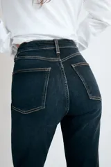 Jeans de tiro alto con cinco bolsillos, diseño cropped flare y bajo sin costuras. Cuenta con cierre frontal de cremallera y botón metálico.
