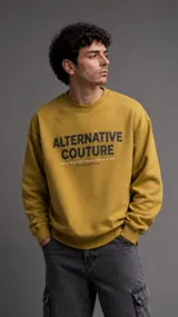Buzo de cuello redondo color mostaza, con estampa frontal en color negro que incluye el texto 'ALTERNATIVE COUTURE' y detalles de ciudades. Presenta puños y ruedo acanalados.