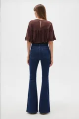 Pantalón jean de corte oxford, tiro alto, con bolsillos y diseño de pernera ajustada en muslos y acampanada desde las rodillas.