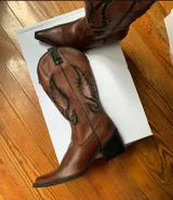 Bota texana de cuero color marrón con bordados negros en el lateral.