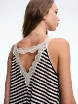 Top de tirantes con diseño a rayas horizontales en blanco y negro, confeccionado con terminaciones de encaje en el escote y en el ruedo.