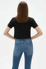 Remera cropped de algodón negra con cuello a la base, mangas cortas y estampado frontal de cerezas con la palabra "HELLO".