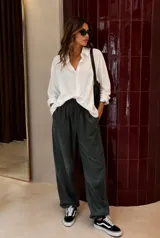 Camisa de corte oversize, color blanco, con cuello clásico, cierre frontal de botones y mangas largas con puños.
