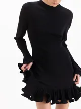 Vestido corto de punto celeste, con silueta ajustada, cuello medio alto y mangas largas. Cuenta con volados plisados en los puños y en el ruedo.