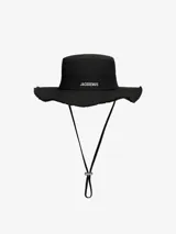 Sombrero de expedición Jacquemus modelo Le Bob Artichaut de color negro, confeccionado en algodón. Presenta ala ancha deshilachada, pespuntes decorativos, cordón ajustable con tope metálico y el logo de la marca en letras metálicas plateadas en el frente.