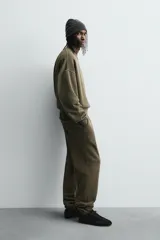 Sudadera de corte boxy fit con efecto lavado, cuello redondo con detalle de costura triangular y acabados con bordes deshilachados en el ruedo y las costuras. Presenta manga larga con puños acanalados.
