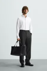 Camisa de manga larga color celeste claro, corte slim fit, con cuello italiano abierto y cierre frontal de botonadura.