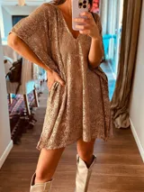 Vestido suelto de encaje color dorado con lentejuelas, escote en V y mangas cortas.