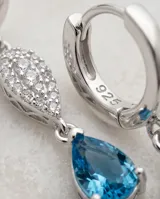 Caravanas colgantes de plata 925 con diseño de doble gota, una superior con pavé de circonias blancas y una inferior con una circonia central color celeste.