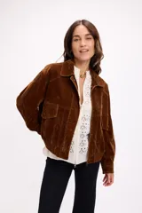 Cárdigan de tejido calado color blanco, con cierre frontal completo, cuello alto y mangas largas. Presenta un diseño con patrón de perforaciones geométricas y ajuste relajado.