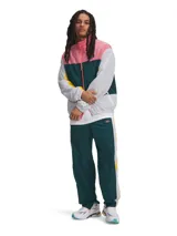 Pantalón deportivo Under Armour de corte holgado, color verde petróleo con franjas laterales en blanco y amarillo. Presenta cintura elástica con cordón, puños elásticos en los tobillos y logo de la marca en la parte superior.