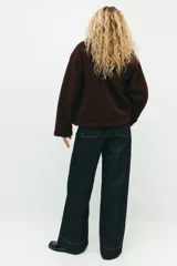 Campera de sherpa color bordó, con cuello alto, cierre frontal y bolsillos de parche. Diseño de hombros caídos y sin forro.