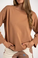 Sweater color marrón claro con textura tipo waffle, corte holgado y mangas largas.