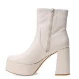 Botas de caña media Miss Carol modelo Placid, confeccionadas en material sintético elastizado color negro. Presentan una plataforma alta y un taco cuadrado robusto, con un diseño minimalista y ajustado al tobillo.