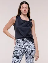 Blusa de satén color negro, de corte fluido, con escote asimétrico y un aro metálico decorativo en el hombro.