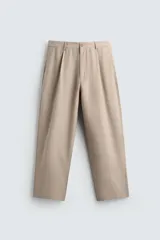 Pantalón de corte relajado confeccionado en tejido con mezcla de lyocell. Presenta cintura con trabillas, cierre frontal con cremallera y botón, pliegues en el delantero, bolsillos laterales y bolsillos traseros de vivo.