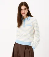 Blusa de punto a rayas horizontales celestes y blancas, con cuello polo celeste, cierre frontal con botones, bolsillo aplicado en el pecho y mangas largas.
