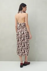 Vestido midi con estampado abstracto en blanco y negro, escote halter y falda acampanada con abertura frontal.