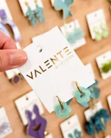 Aros colgantes con aro dorado y dije de flor celeste de acrílico.