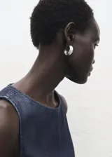 Top sin mangas de efecto denim con cuello redondo y diseño ajustado en la cintura con ligero vuelo en el bajo. Cuenta con cierre de botón en la parte posterior del cuello.