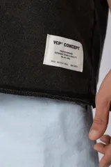 Remeron de corte oversized con cuello redondo y mangas cortas. Presenta un acabado de tela con efecto desgastado y costuras visibles en los bordes, con una etiqueta pequeña en el lateral inferior.
