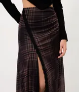 Pollera midi de tul con estampado a cuadros, diseño con abertura lateral decorada con encaje y bajo asimétrico en pico. Cuenta con cintura elástica y forro interior.