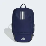 Mochila deportiva Adidas de color azul marino, con tres franjas blancas verticales en el panel frontal y el logo de la marca en la parte inferior. Posee bolsillos laterales de malla y un compartimento inferior con cierre.