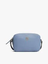Bandolera Tommy Hilfiger azul con correa ajustable negra, cierre superior y logo dorado de la marca en el frente.