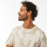 Remera de manga corta color beige con estampado de hojas de palmera blancas. Corte clásico y cuello redondo.