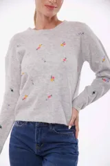 Sweater verde claro con bordado de flores pequeñas.