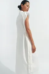 Vestido midi camisero de algodón color negro, con cuello solapa, sin mangas y cierre frontal con botones ocultos por solapa. Incluye cintura ajustable con tiras de lazada lateral en el mismo tejido.