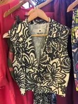 Chaleco negro con estampado floral, de corte midi y escote en V.