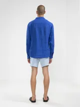 Camisa de manga larga confeccionada 100% en lino, color verde claro, con calce recto y relajado. Presenta frente abotonado con botones de coco con logo y el patch característico de Polonio.