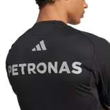 Remera deportiva de manga corta color negro, diseñada para el equipo Mercedes-AMG PETRONAS F1 Team. Confeccionada con tecnología AEROREADY para la gestión de la humedad, incluye logotipos de patrocinadores en el pecho y las clásicas tres tiras de Adidas en los hombros.
