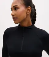 Remera deportiva de manga larga Get Over, confeccionada en tejido elástico de poliamida y elastano. Presenta un diseño ajustado al cuerpo, cuello alto y cierre frontal parcial con cremallera.