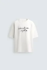 Camiseta de corte relajado confeccionada en algodón, con cuello redondo, manga corta y estampado de texto en contraste en el frente.
