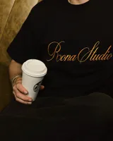 Remera blanca de corte holgado con bordado en el pecho con la leyenda "Roona Studio".