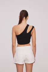 Top corto blanco de algodón, con un solo hombro y corte asimétrico.