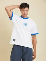 Remera blanca de manga corta estilo ringer, con cuello redondo y ribetes en color azul. Presenta un pequeño estampado circular en el pecho.