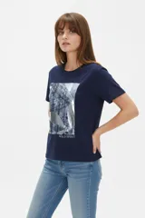 Remera de manga corta de algodón en color blanco, con cuello redondo y diseño holgado. Cuenta con un estampado frontal central con detalles metalizados estilo foil.