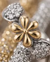 Anillo de plata 925 con aplique central en forma de flor en oro de 18k y detalles laterales con circonias engarzadas.