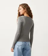 Cardigan blanco de punto con botones negros, escote en V y mangas largas. Marca Blue Steel.