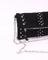 Bandolera de cuero negro con diseño de tachas metálicas plateadas. Cuenta con cierre frontal y correa de cadena metálica desmontable.